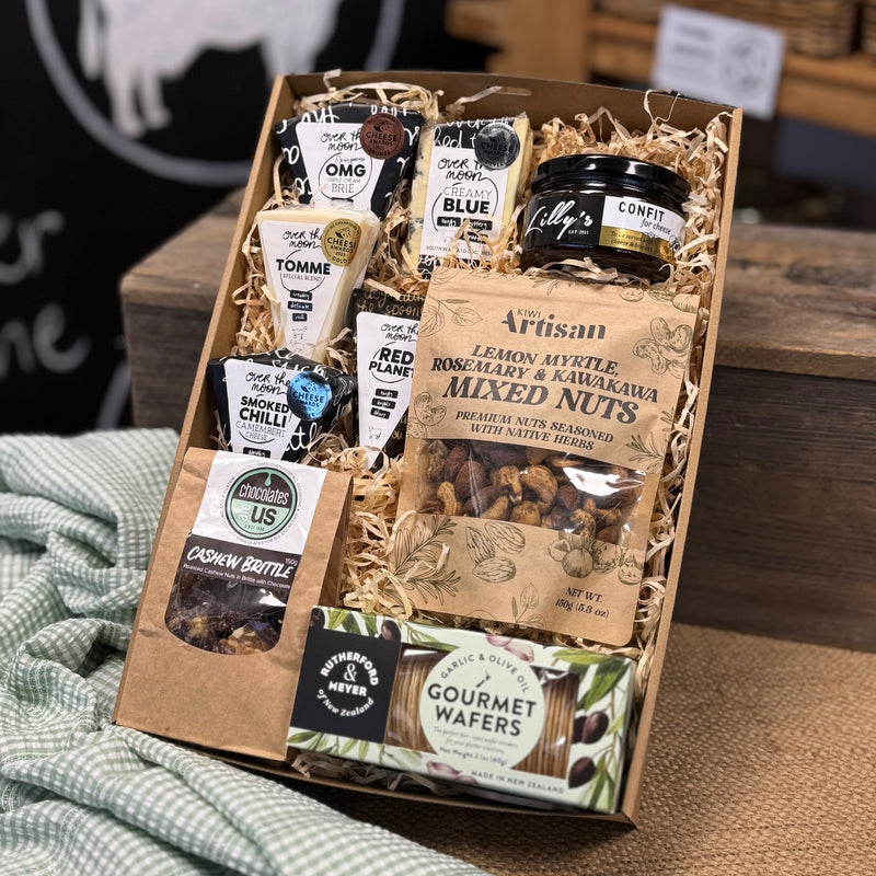Gift box with assorted snacks and treats on a wooden surface